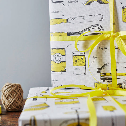 Gift wrap featuring repeating pattern of yellow kitchen and baking items, Yellow gift wrap featuring various baking and cooking tools, Gift wrap featuring various baking items in the colors yellow and charcoal