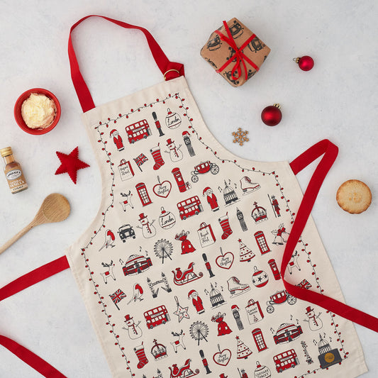 Children's London Christmas apron featuring repeating London landmarks, Kids kitchen apron featuring iconic London Christmas icons, Children's Christmas kitchen apron with red strap, Cotton Children's Christmas apron featuring ice skates and The London Ey