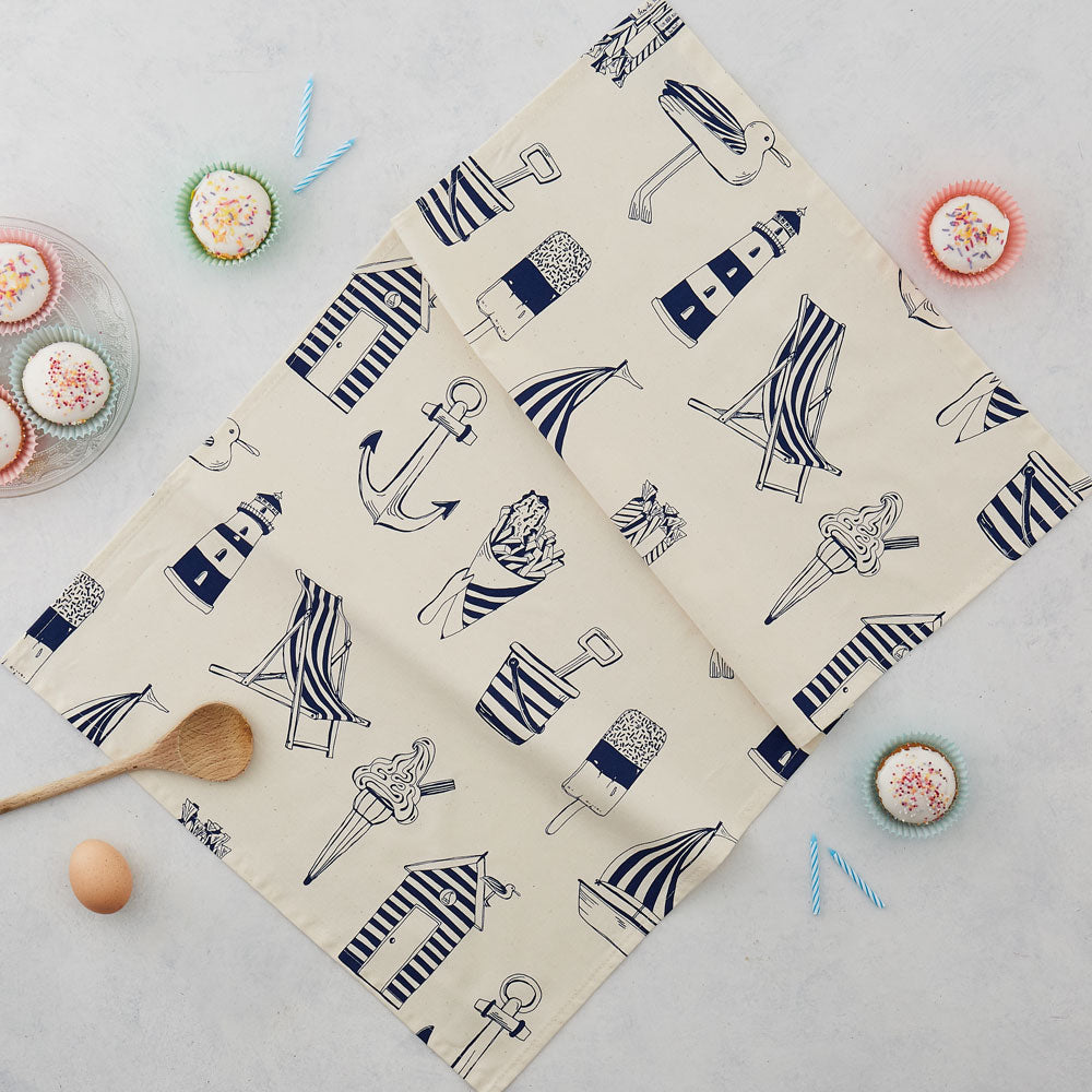 Tea towel featuring repeating nautical icons design in navy, Hand illustrated nautical tea towel featuring repeating pattern of navy nautical icons, Kitchen towel featuring nautical design in navy, Nautical dish towel featuring repeating pattern of beachs
