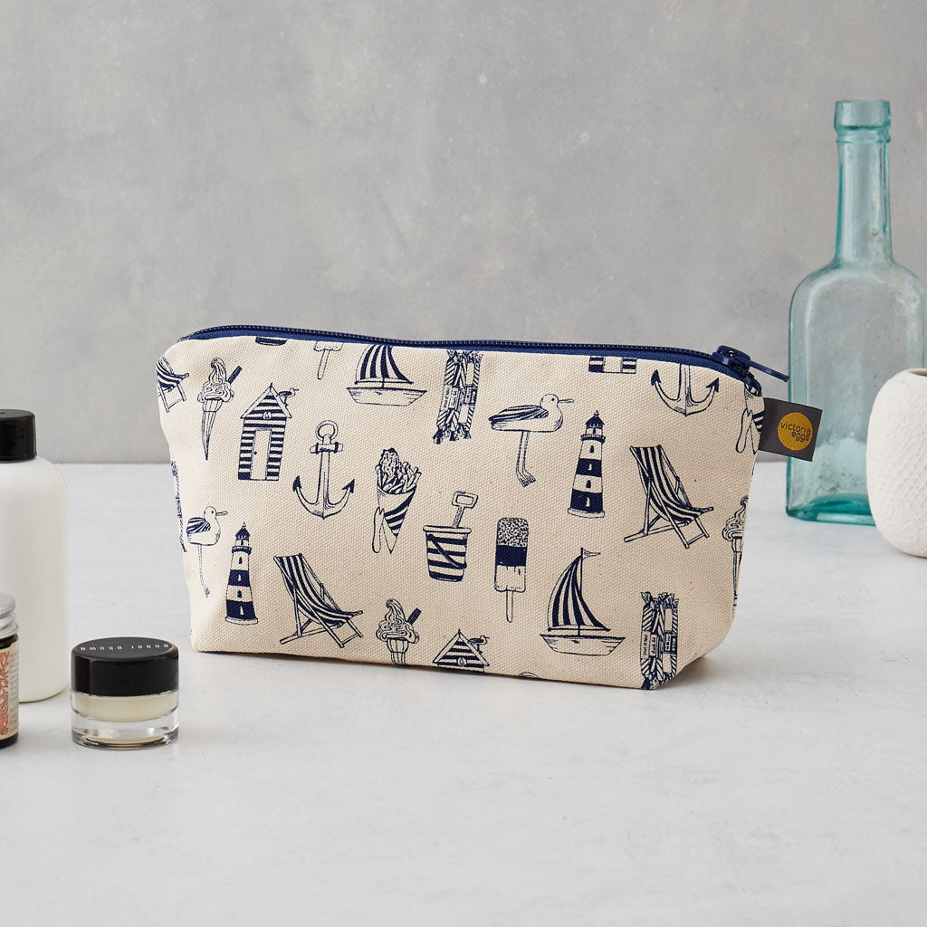 Cosmetic bag featuring repeating nautical design in navy, Pencil case featuring nautical design of repeating beachscape icons, Small nautical travel bag featuring repeating design of iconic nautical designs in navy